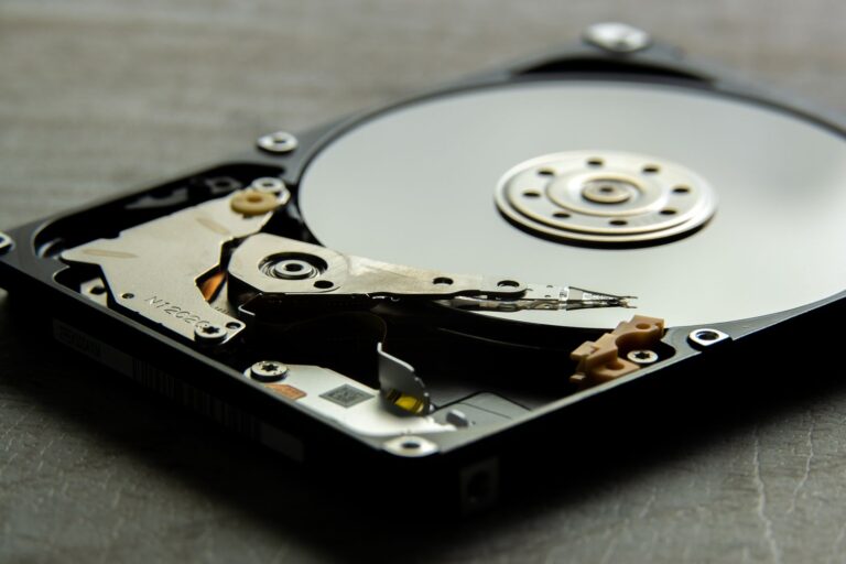Detailed view of an open hard drive, showcasing the disk platter and actuator arm.