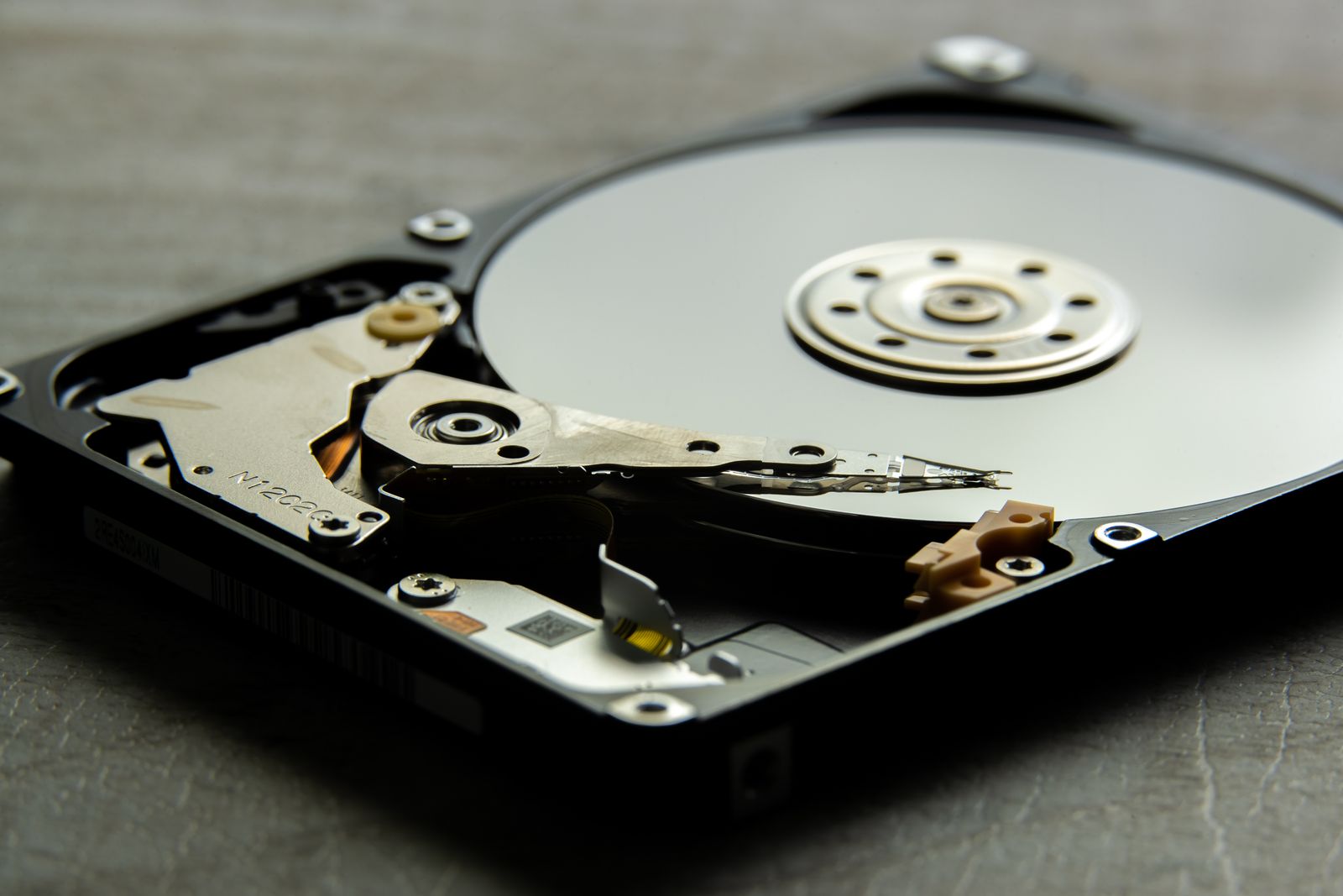 Detailed view of an open hard drive, showcasing the disk platter and actuator arm.